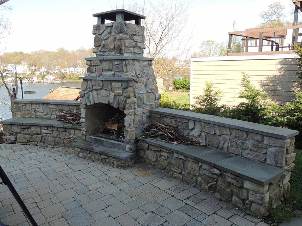 Beautiful Natural Stone Fireplace with a flagstone sitting wall and retaining wall installed in Maryland