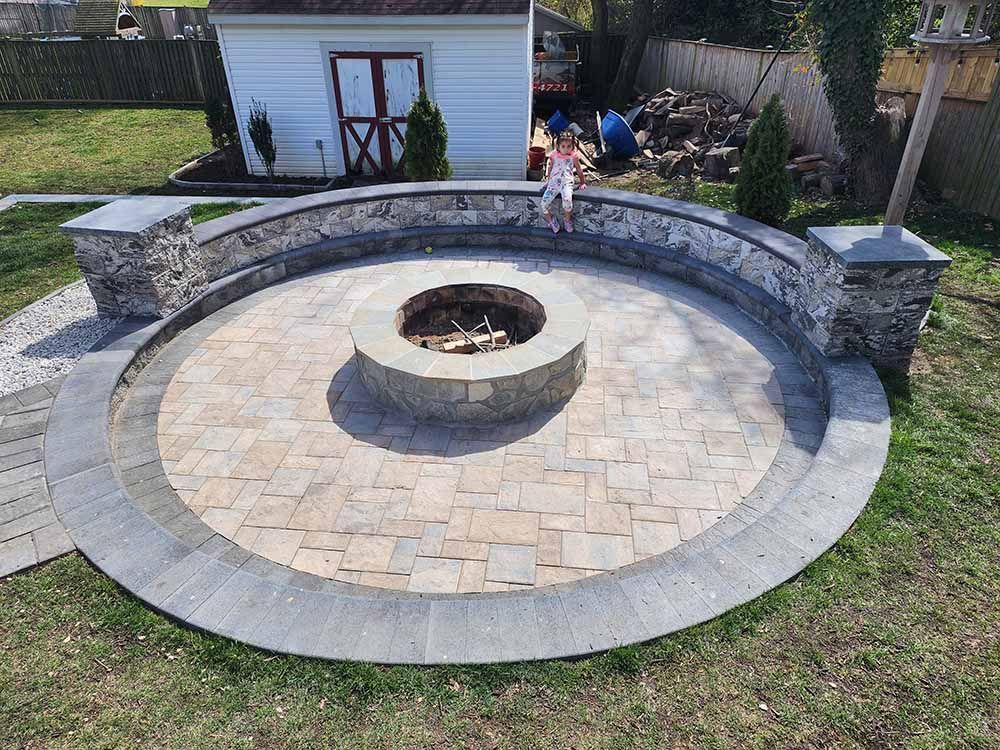 Outdoor Living Space in Jarrettsville, MD A little girl is standing in a circle around a fire pit.
