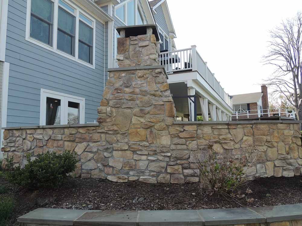 Beautiful Natural Stone Fireplace with a flagstone sitting wall and retaining wall installed in Maryland