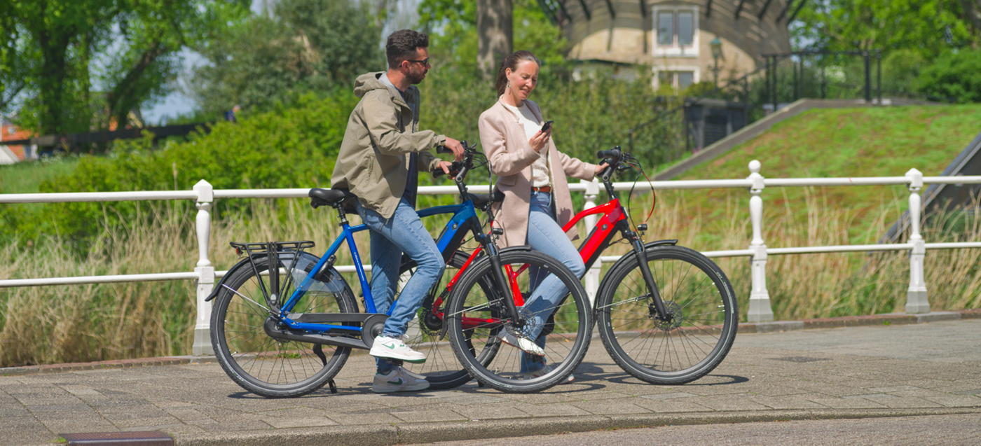 Twee mensen met hun Avalon elektrische tourfietsen op een zonnige dag.