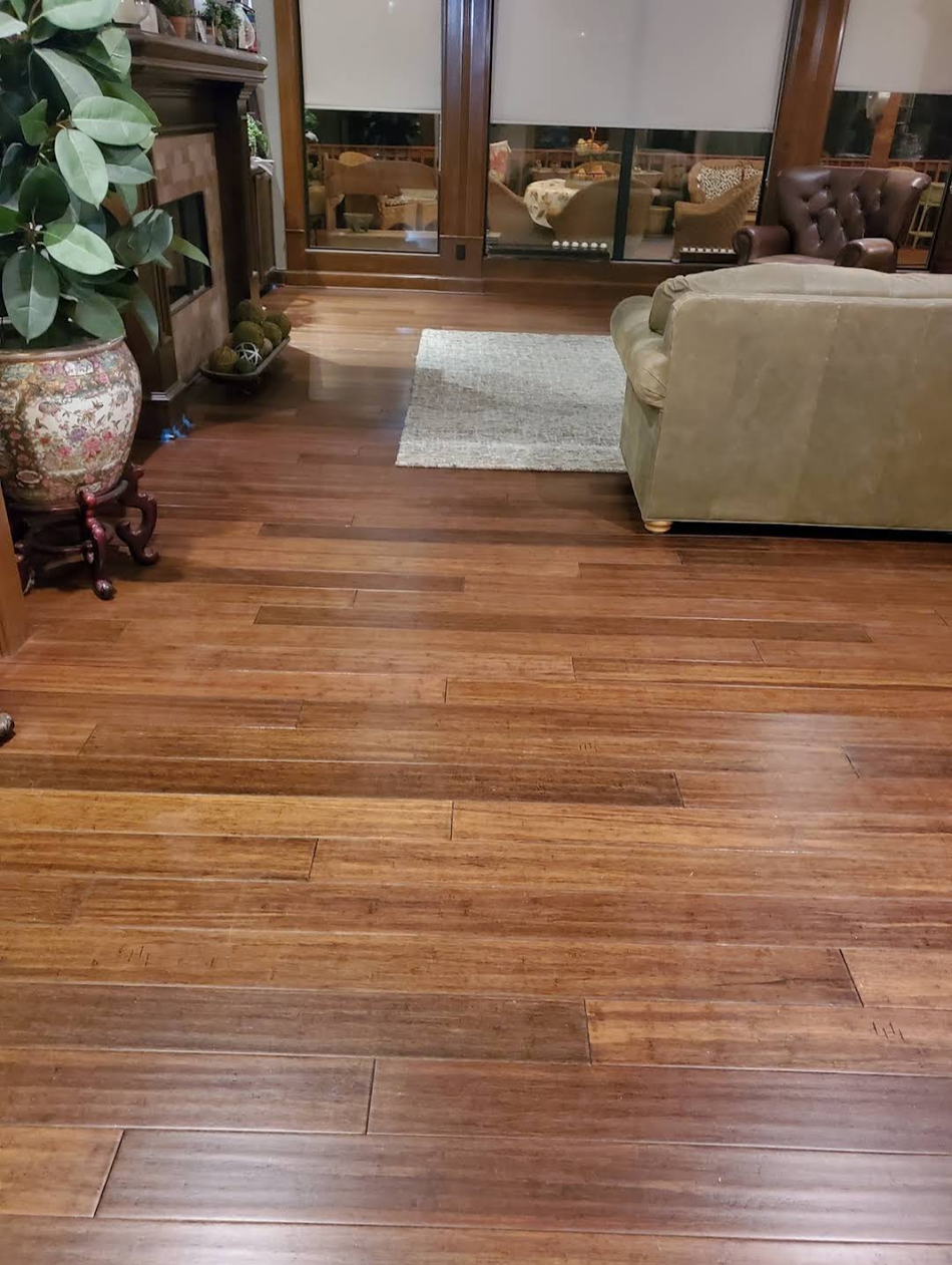 An empty room with hardwood floors and a ceiling fan.