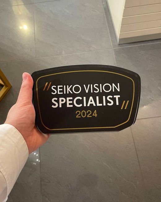 Una persona tiene in mano un cartello con la scritta seiko vision specialist 2024