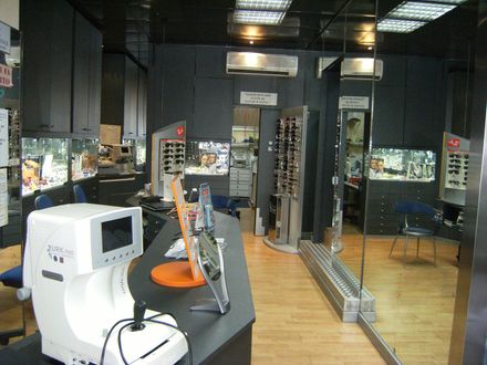 Un negozio di ottica con un grande specchio dietro il bancone