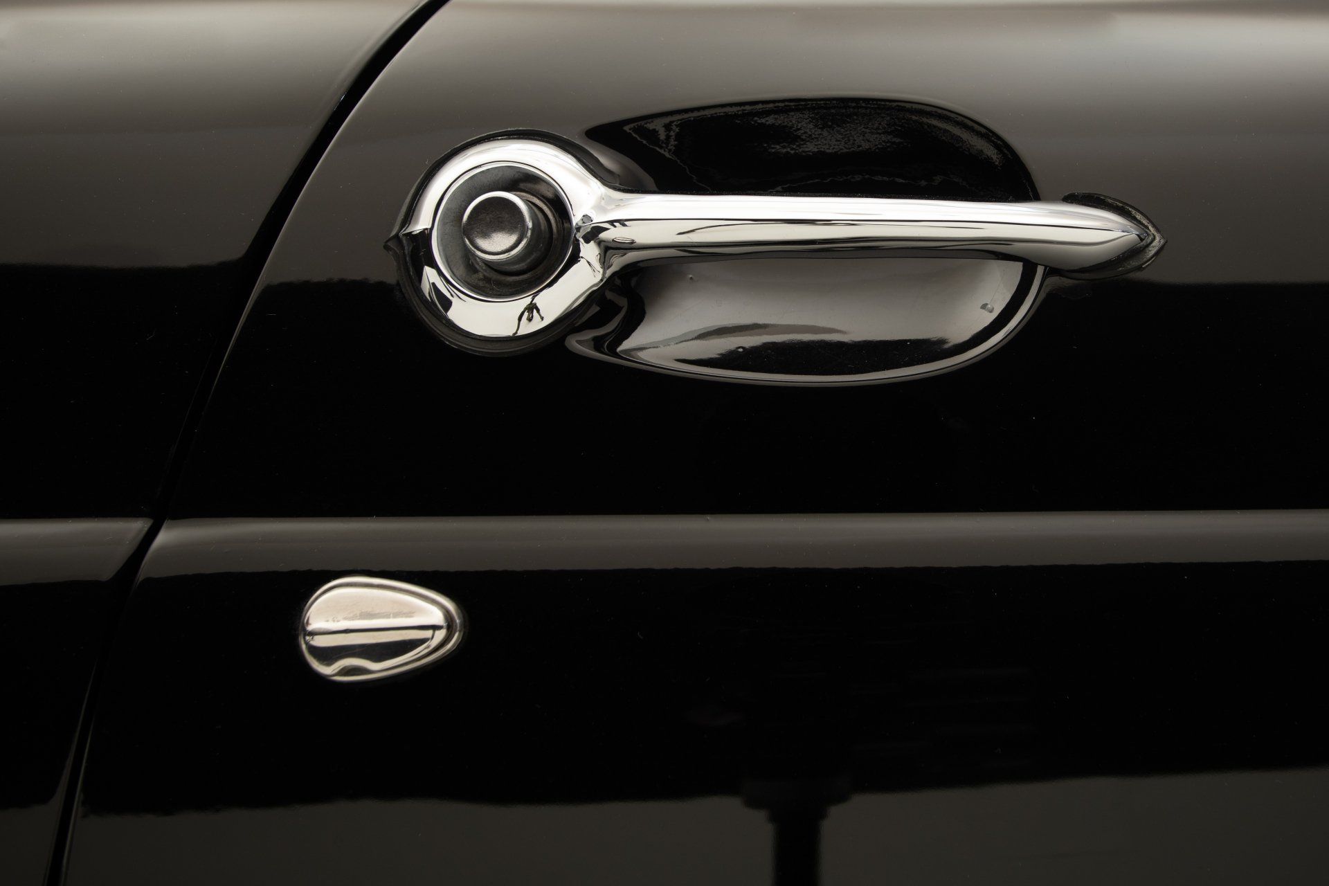 a close up of a chrome door handle on a black car