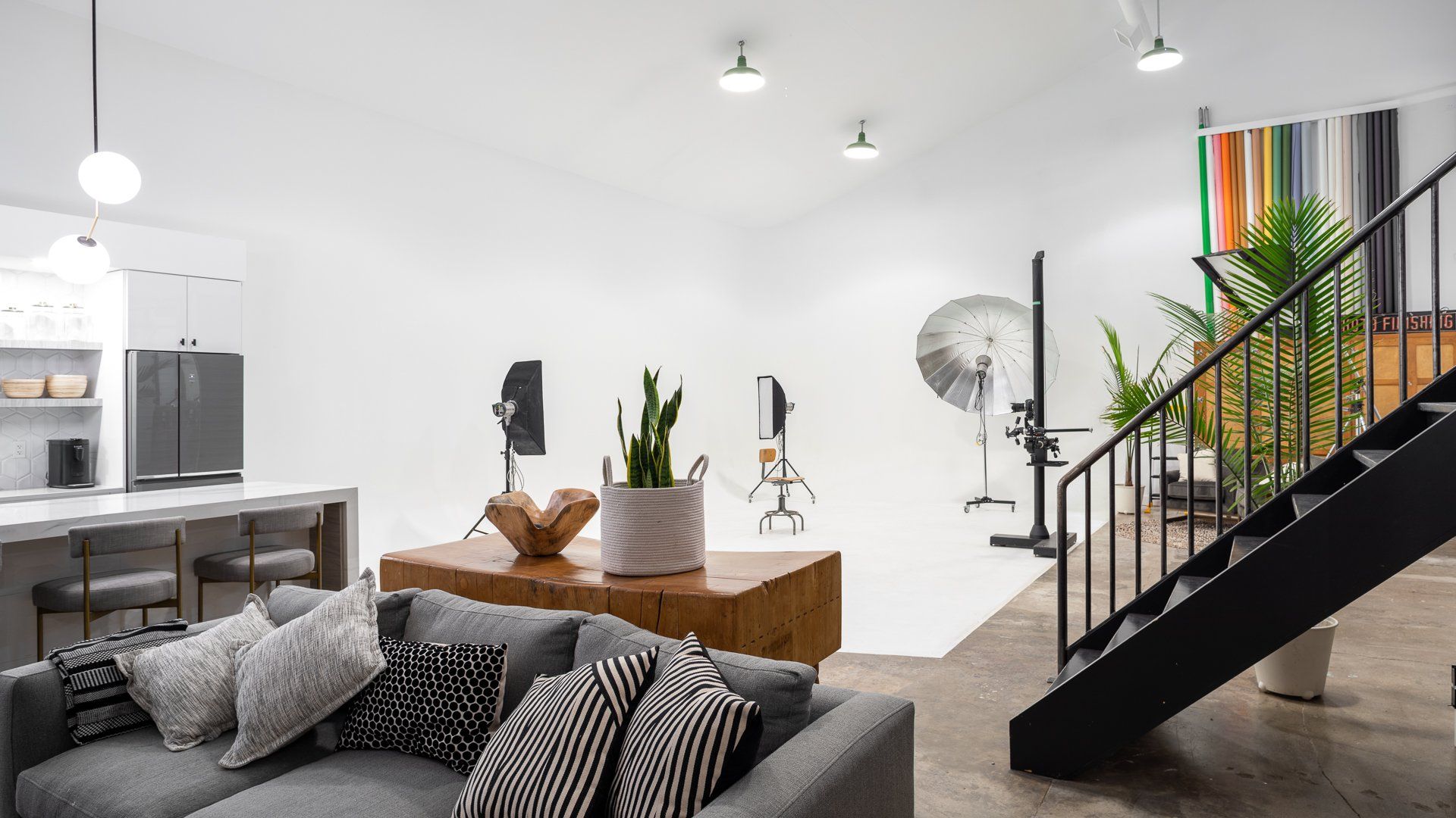 a living room with a couch , stairs and a white wall .