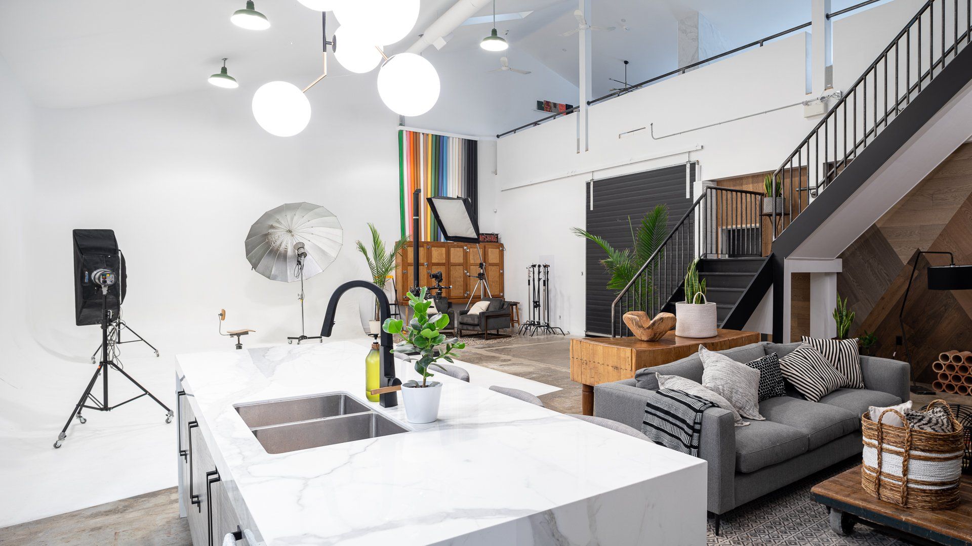 a living room with a couch , sink , and stairs .