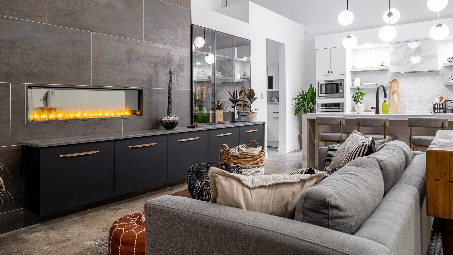 a living room with a couch , fireplace , and kitchen .