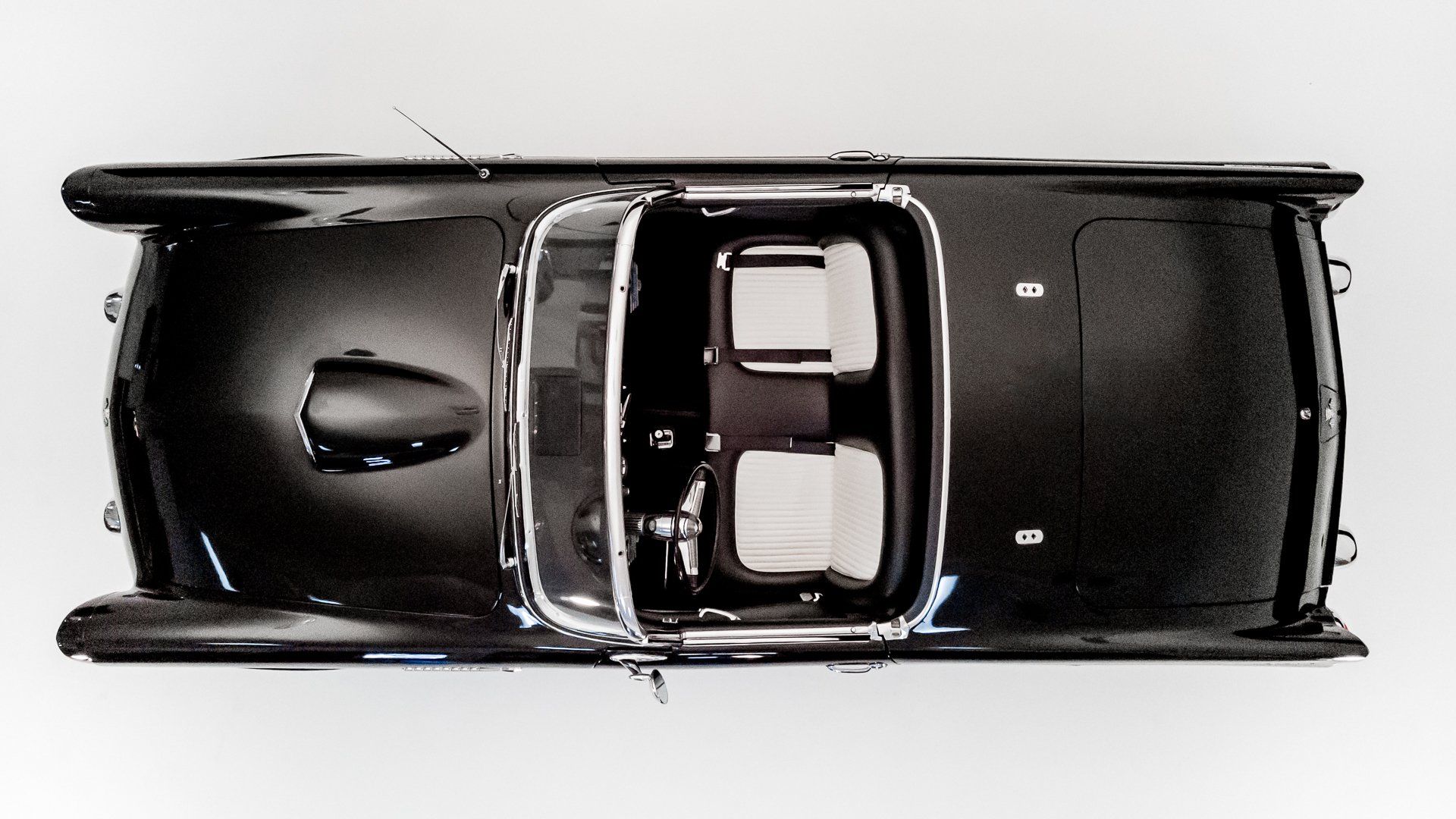 an aerial view of a black car with white seats