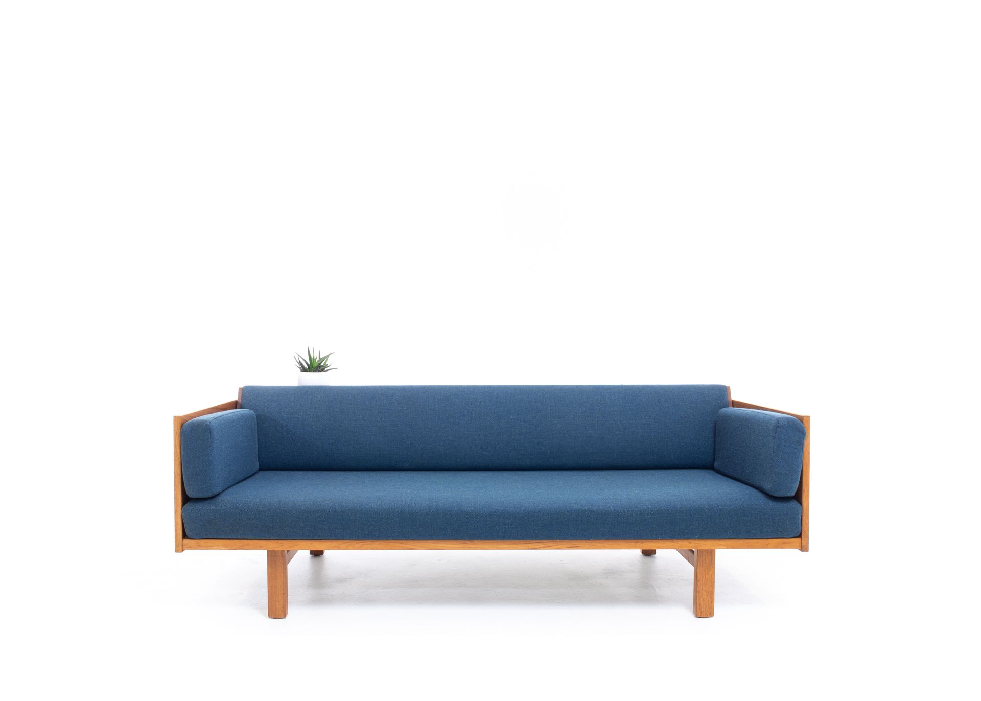 a blue couch with a wooden frame on a white background .