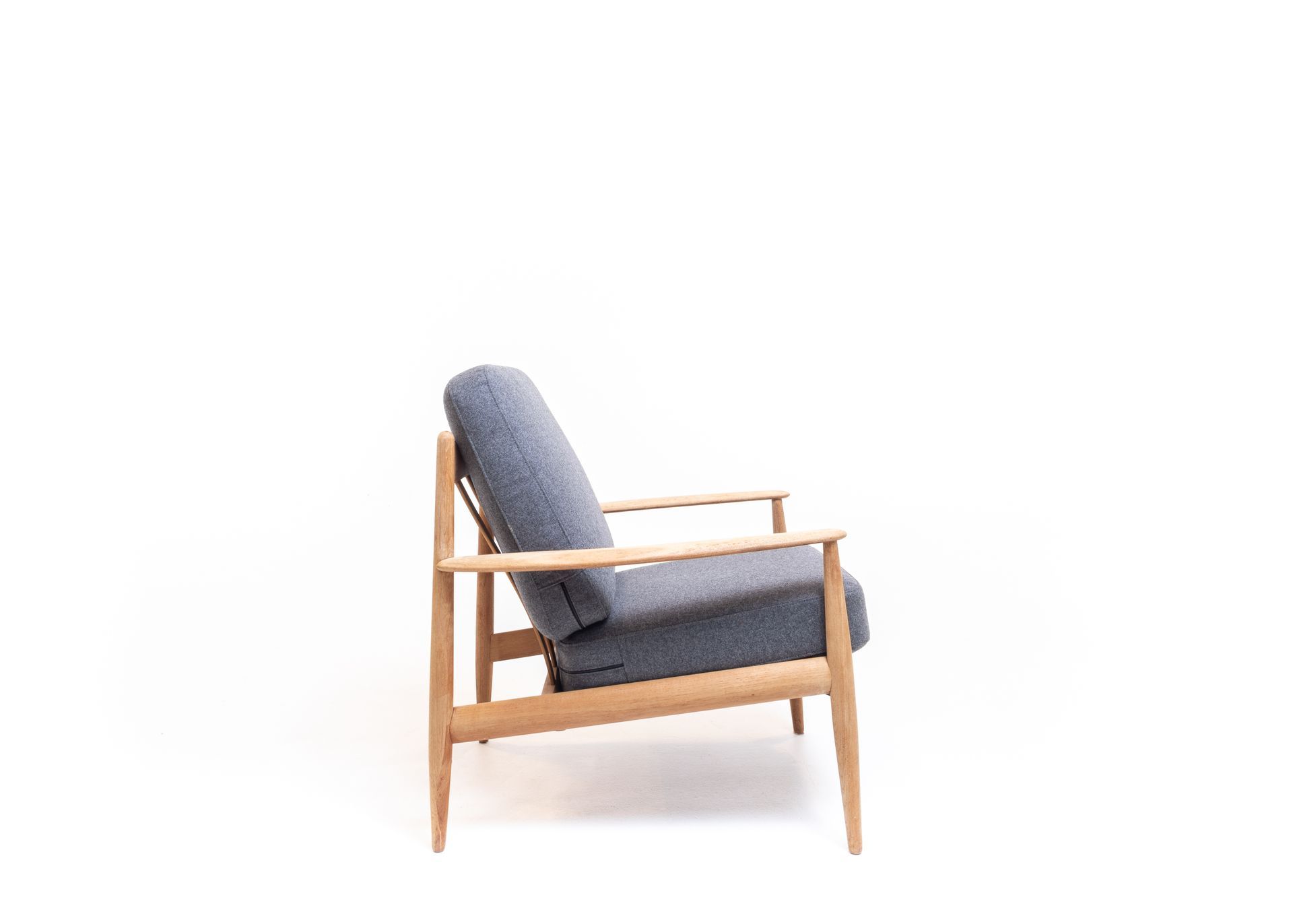a blue chair with wooden armrests on a white background .