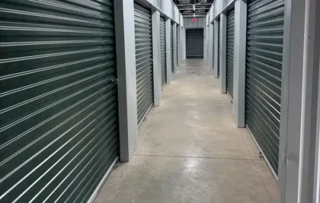 Interior storage hallway with green roll-up doors at Bagby Storage