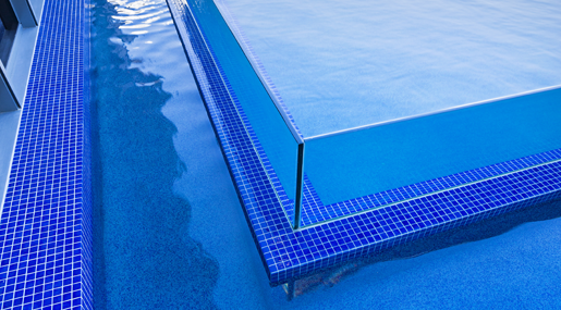 A Close Up Of A Swimming Pool With Blue Tiles Surrounding It — Glass Pool Windows Australia In Old Bar, NSW