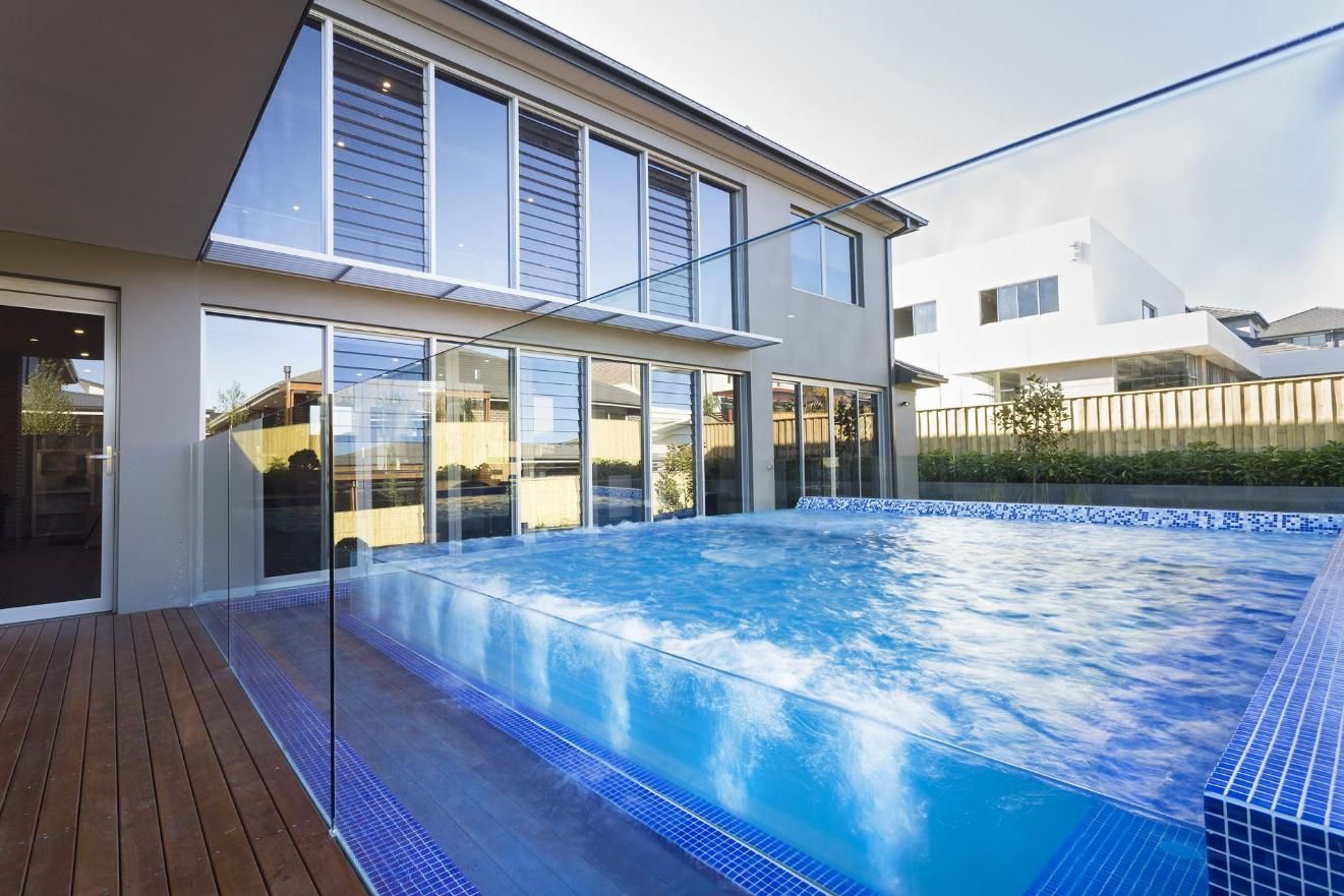 There Is A Large Swimming Pool In The Backyard Of A House — Glass Pool Windows Australia In Old Bar, NSW
