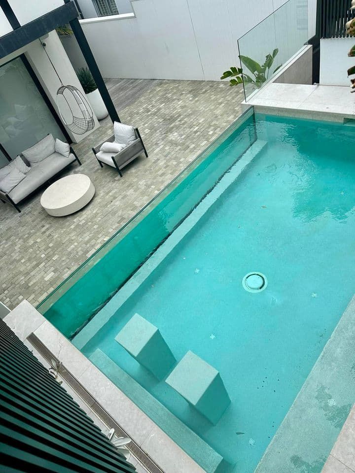 Pool and Patio Area With Lounge Seating — Glass Pool Windows Australia In Broadbeach, QLD