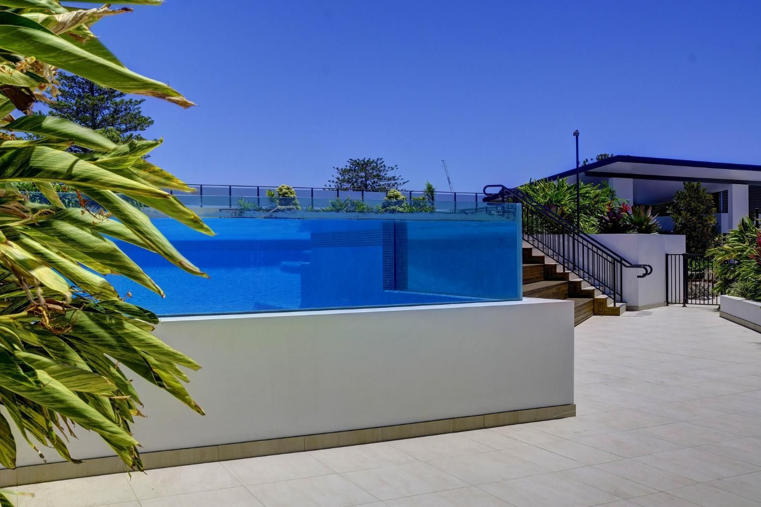 A Large Swimming Pool With Stairs Leading Up To It — Glass Pool Windows Australia In Wollongong, NSW
