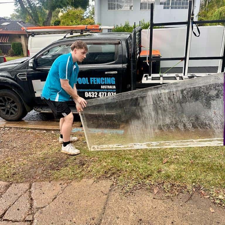 Man Lifting Large Glass Near a Truck — Glass Pool Windows Australia In Manly, NSW