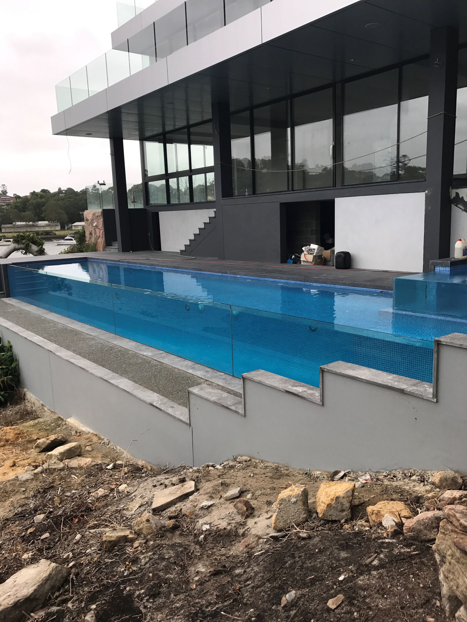 A Large Swimming Pool Is In Front Of A Building — Glass Pool Windows Australia In Old Bar, NSW