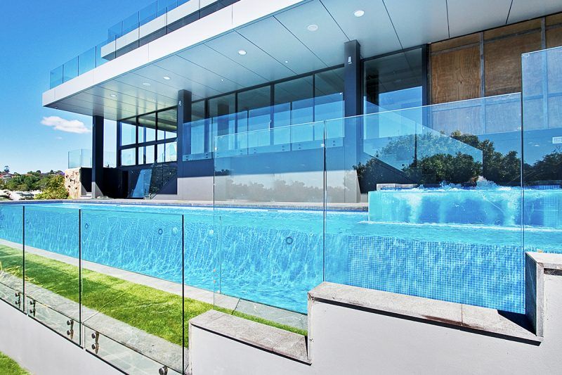 A Large Building With A Swimming Pool In Front Of It — Glass Pool Windows Australia In Old Bar, NSW