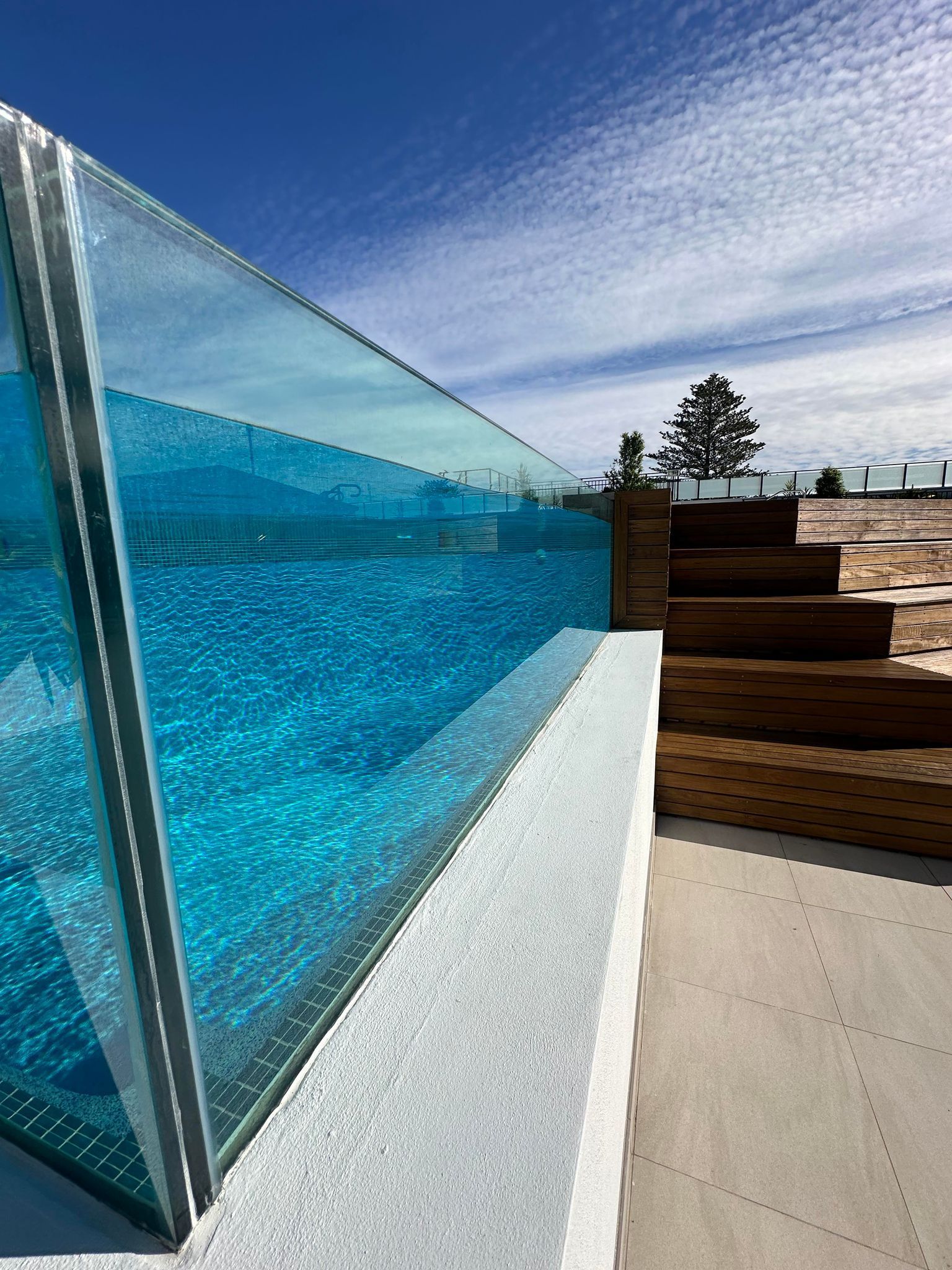 A Swimming Pool With A Clear Glass Fence And Stairs Leading To It — Glass Pool Windows Australia In Old Bar, NSW