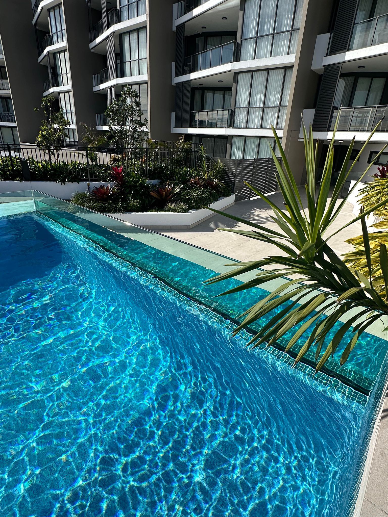 There Is A Large Swimming Pool In Front Of A Building — Glass Pool Windows Australia In Old Bar, NSW