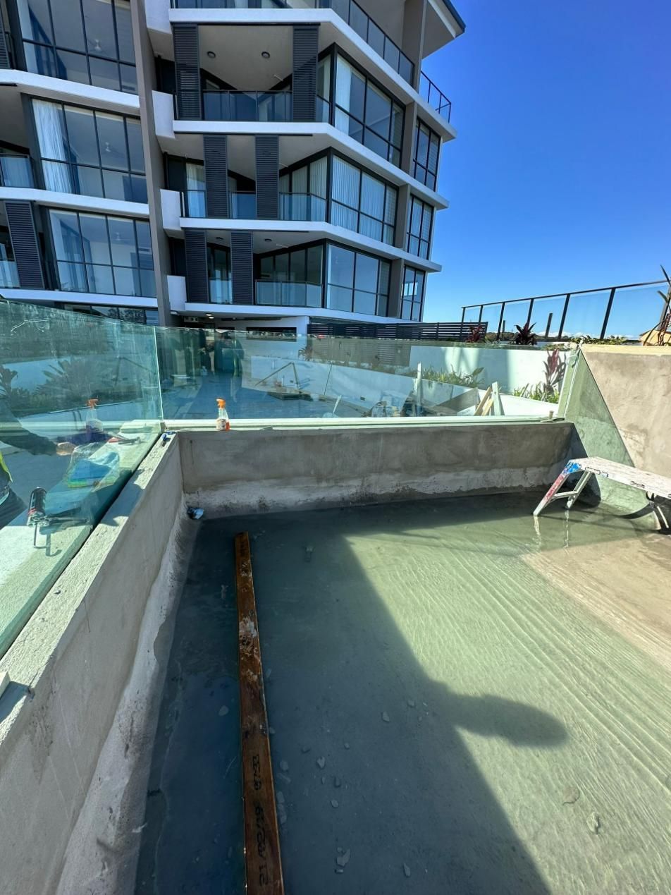 A Large Building With A Swimming Pool In Front Of It — Glass Pool Windows Australia In Old Bar, NSW