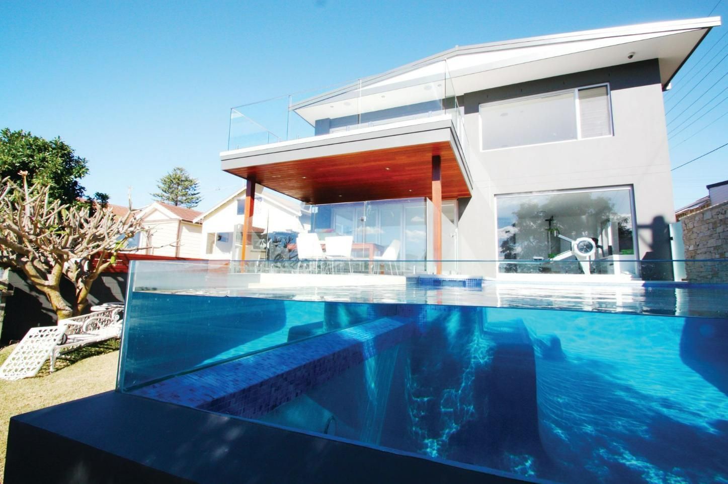A Large House With A Swimming Pool In Front Of It — Glass Pool Windows Australia In Old Bar, NSW