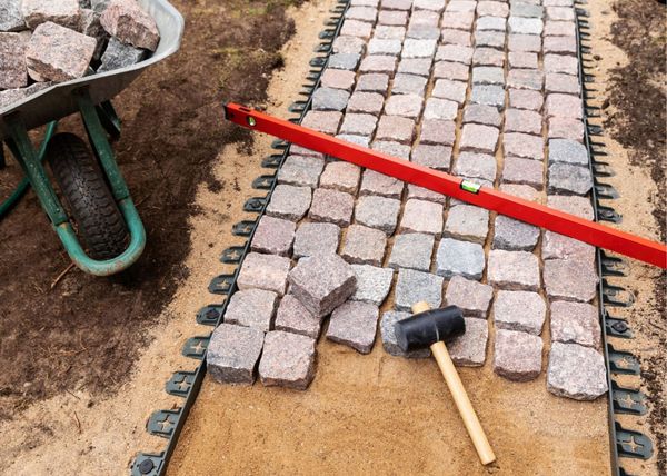 Landscape path patio stones being installed with a mallet.