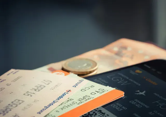 Bilhete de passagem e moedas em cima de uma mesa