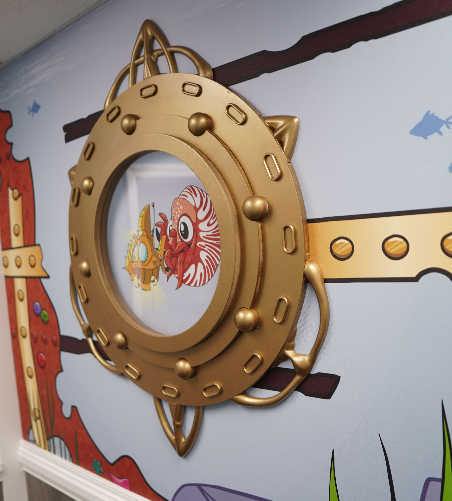 A picture of a fish in a porthole on a wall