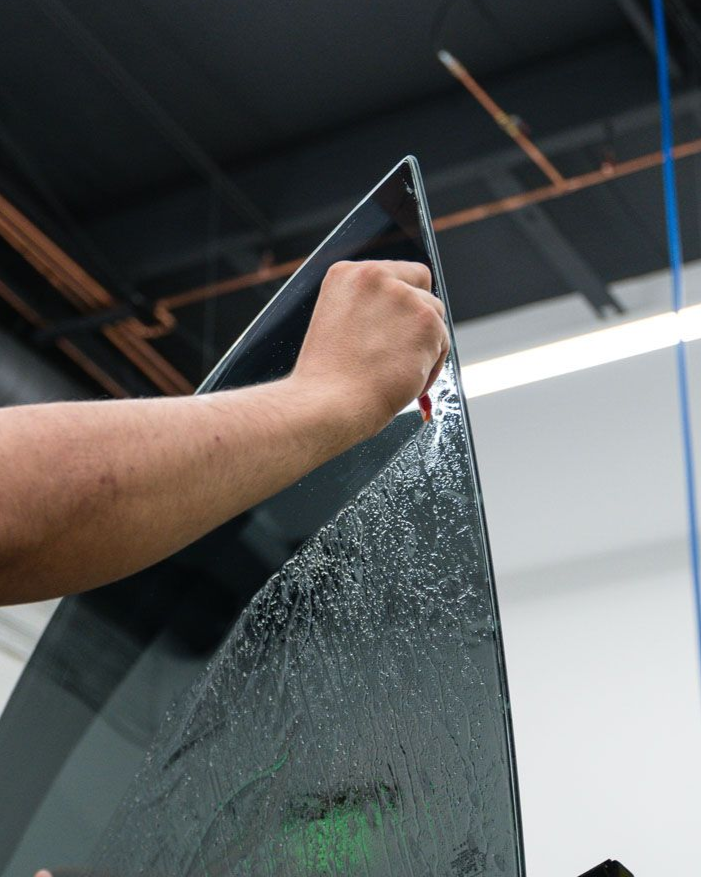 Person applying tint film to a car window