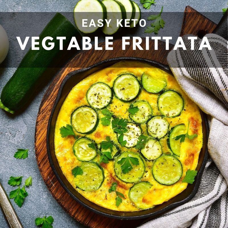Easy keto vegetable frittata in a cast iron pan topped with zucchini slices and parsley.