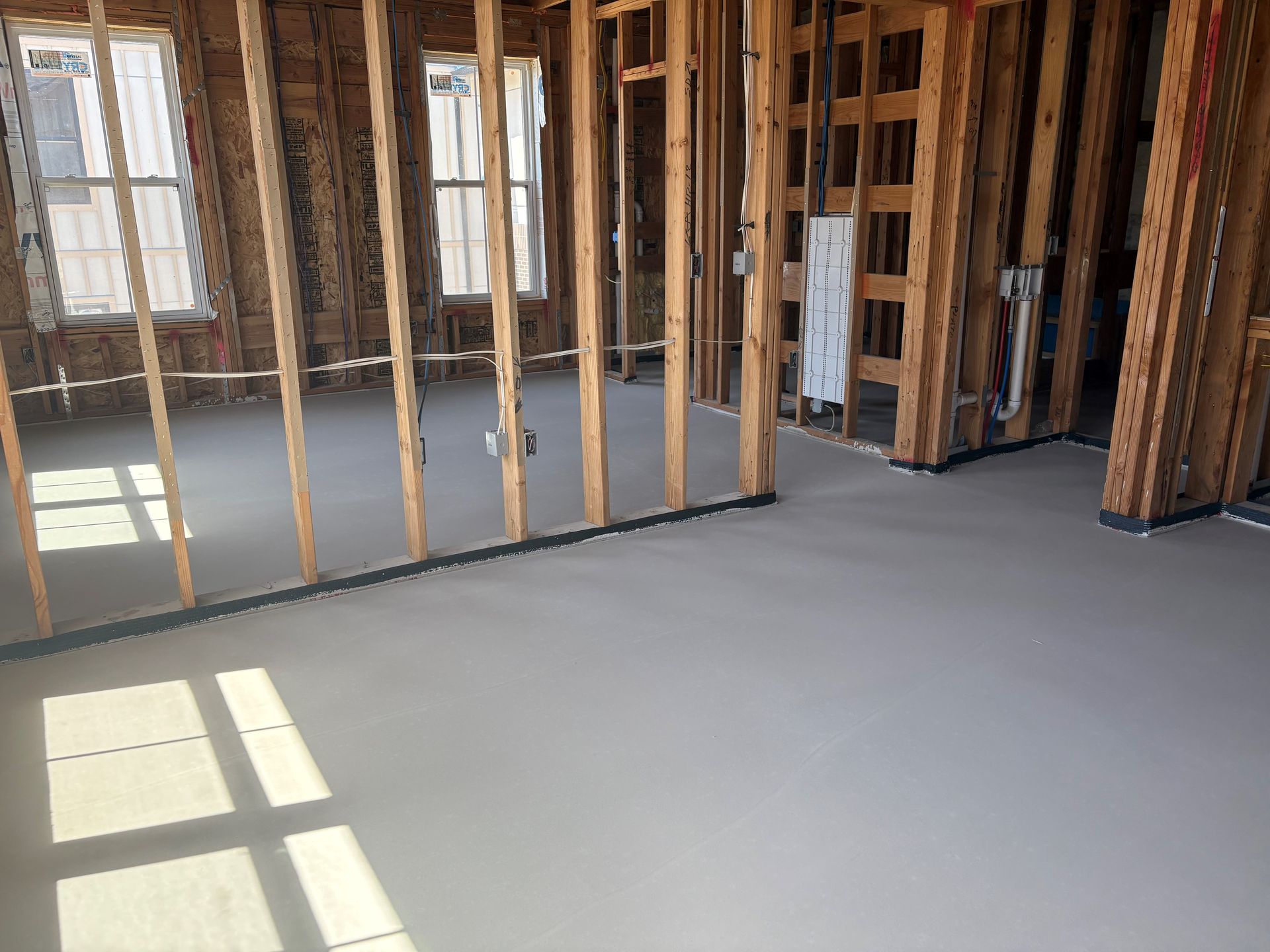 A large empty building under construction with a concrete floor.