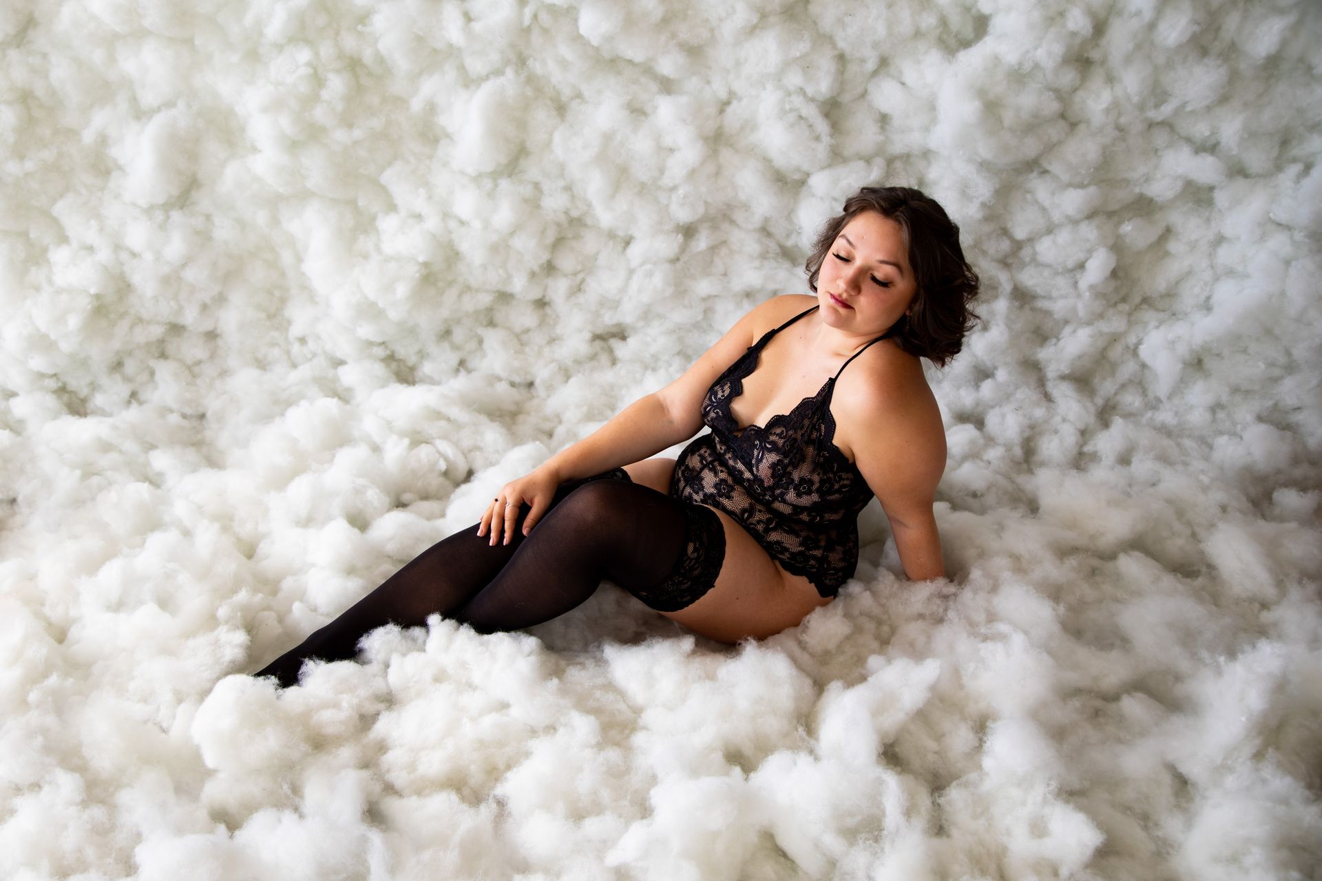 Woman posing in lingerie for boudoir session in cloud scene