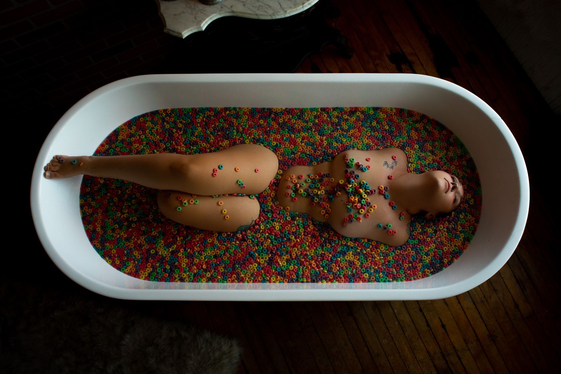 Woman posing in a tub of fruit loops for boudoir session 