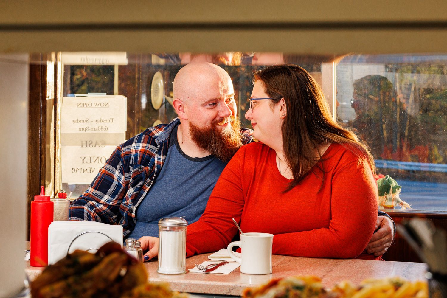 Couple admiring each other during an engagement session at a diner