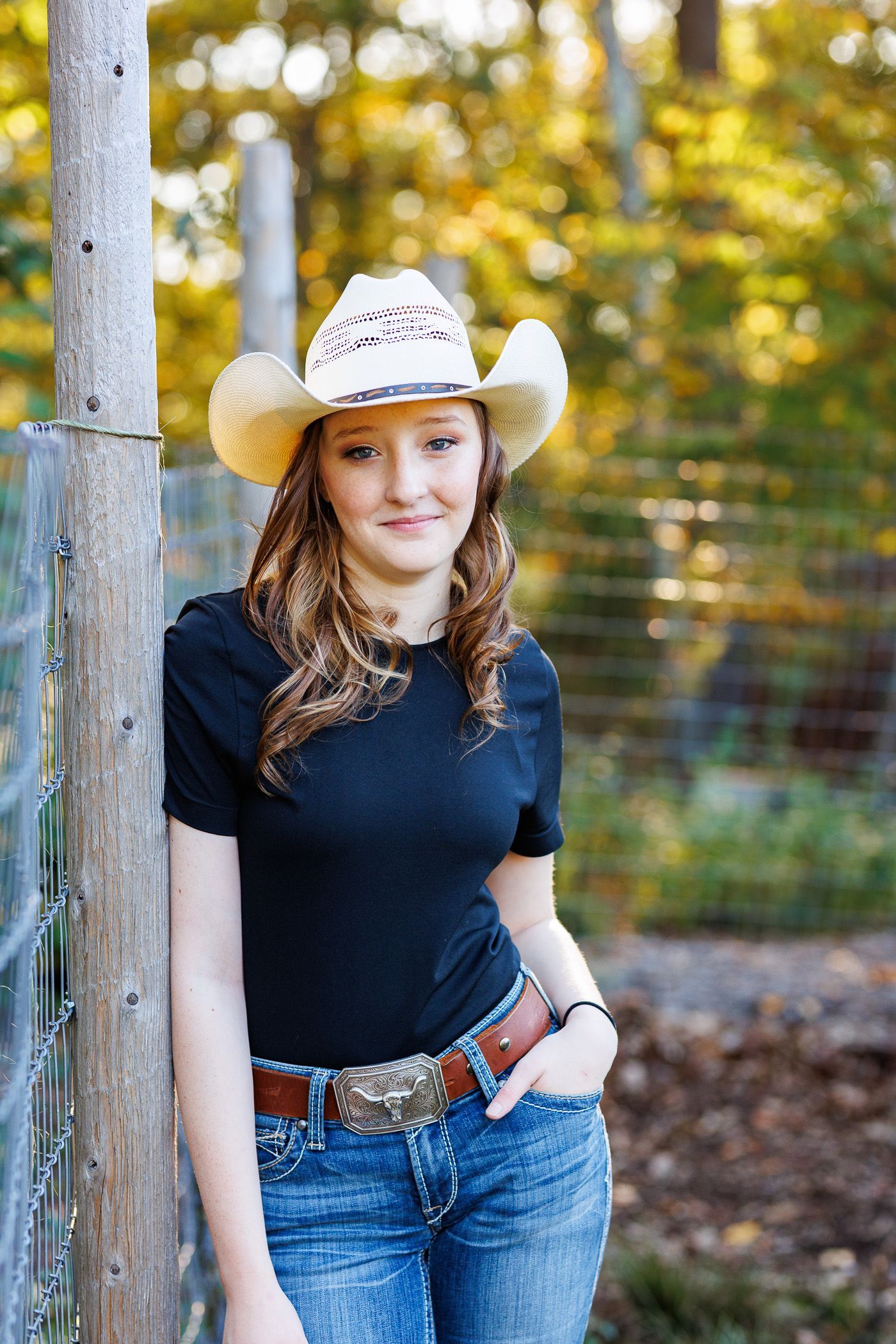 High school senior - senior photography - female student leaning against fence post