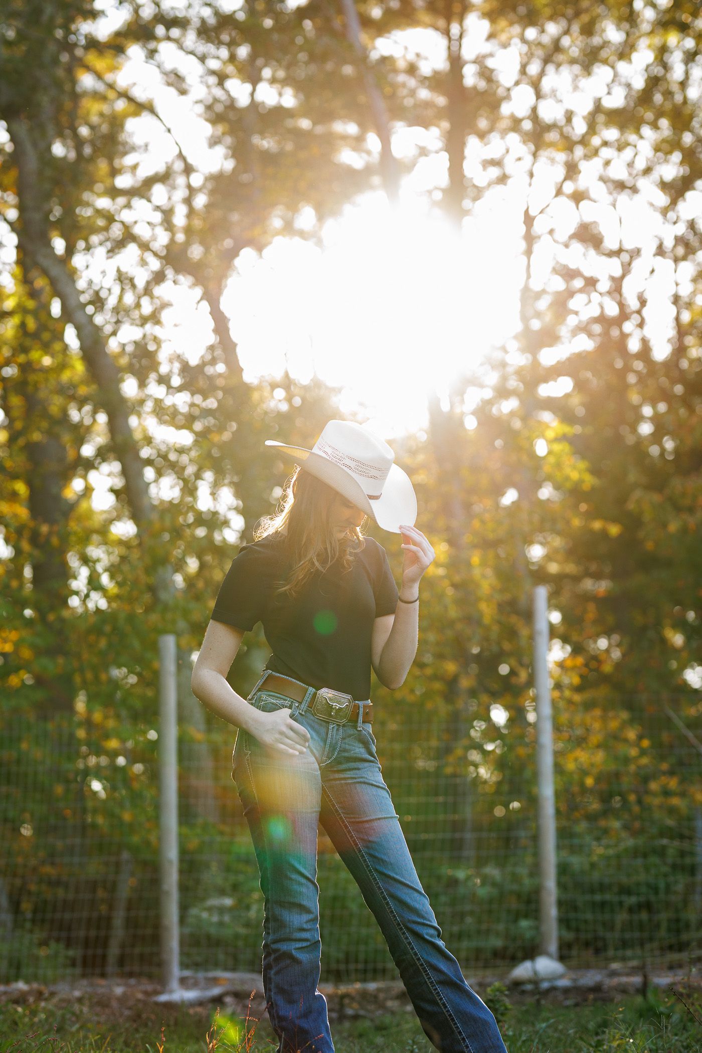 High school senior - senior photography - female student posing with sun behind her