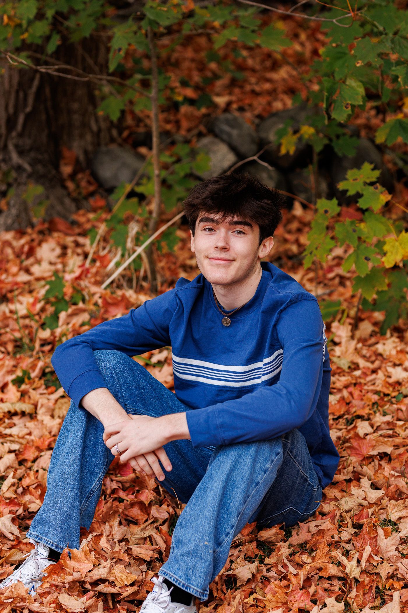 High school senior - senior photography - male student sitting in leaves