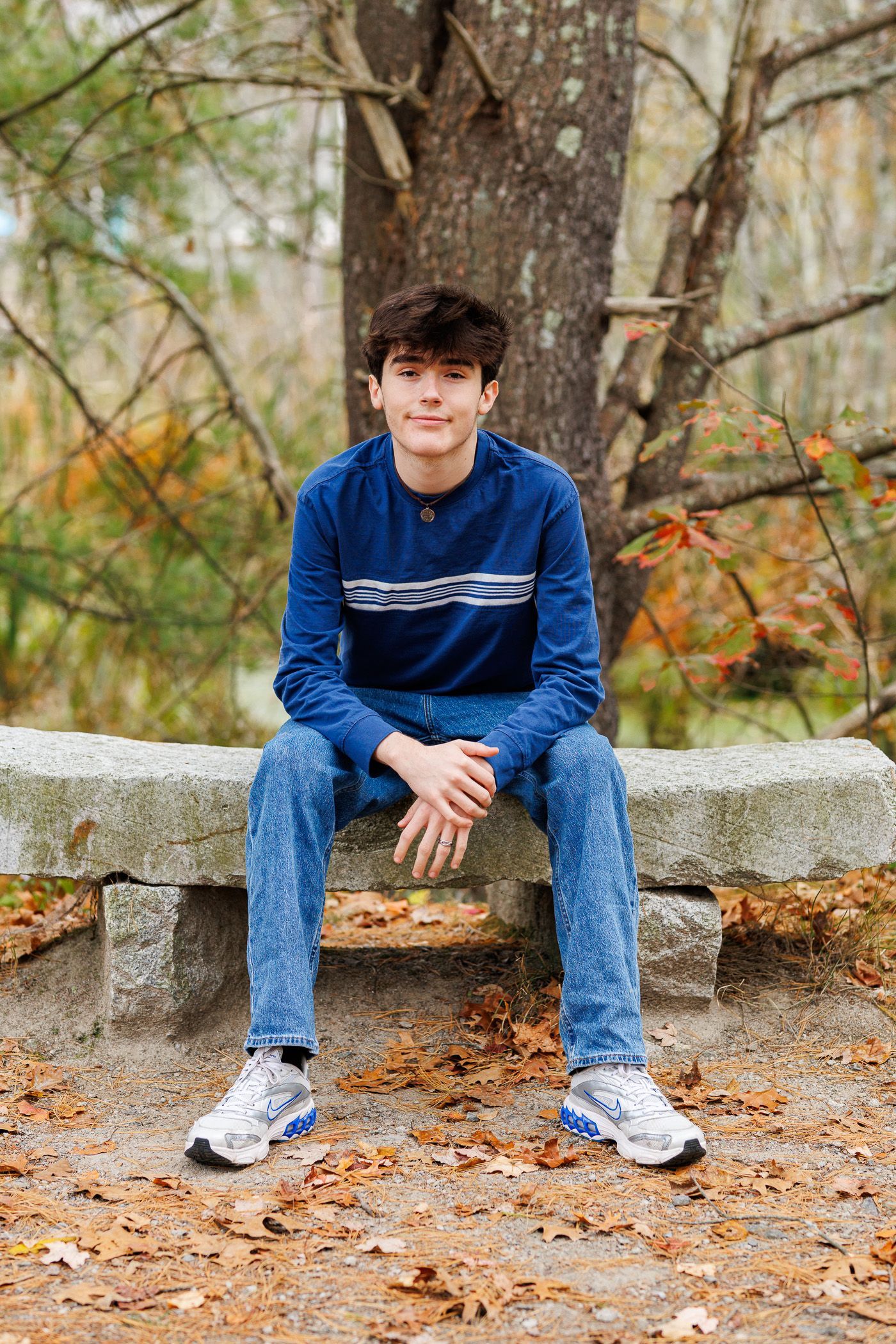 High school senior - senior photography - male student sitting on stone bench