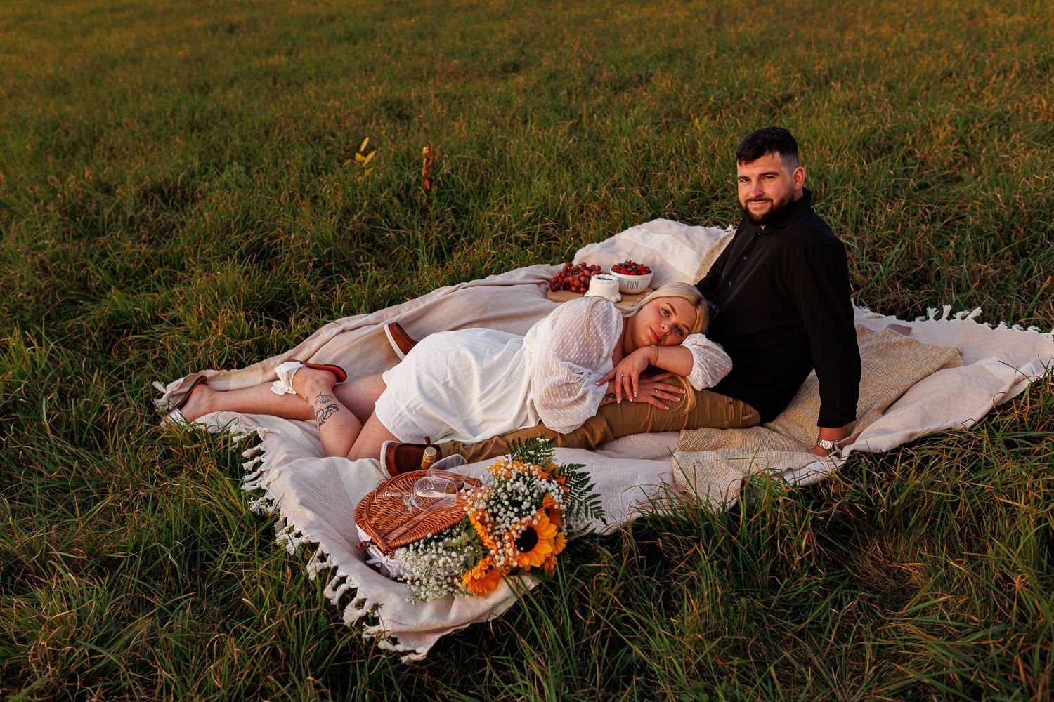 Picnic themed engagement session with couple snuggling