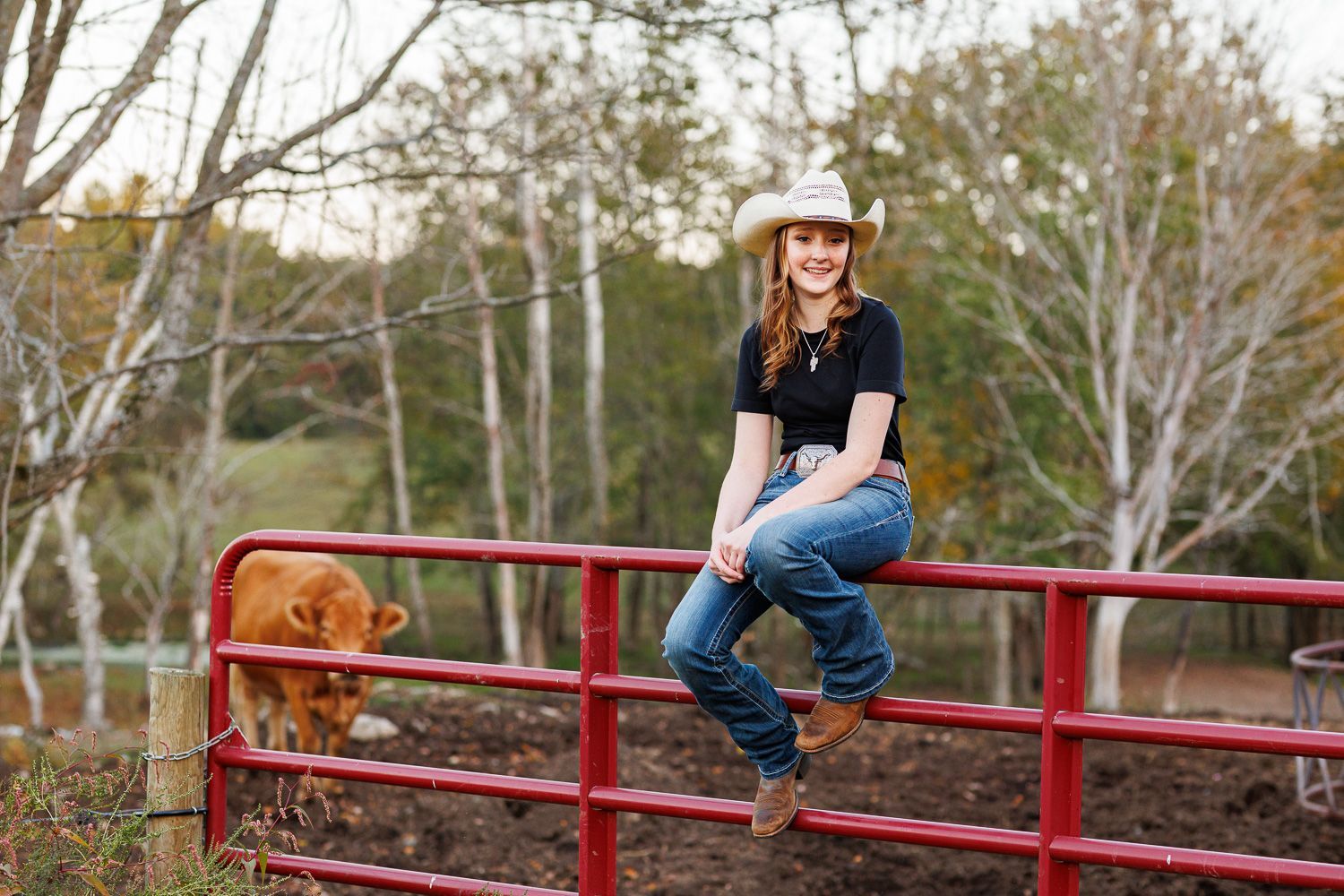 High school senior - senior photography - female student posing on cattle fence