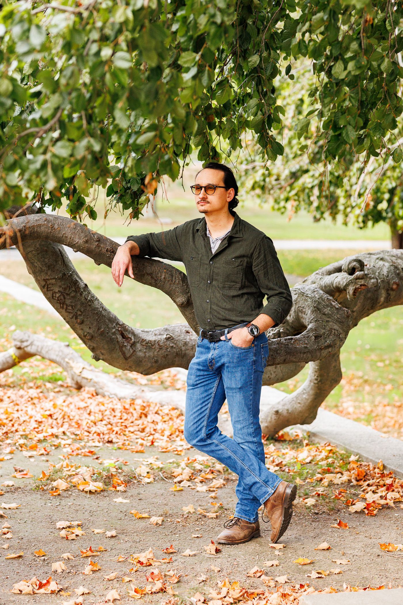 Man posing in Willow tree during engagement session
