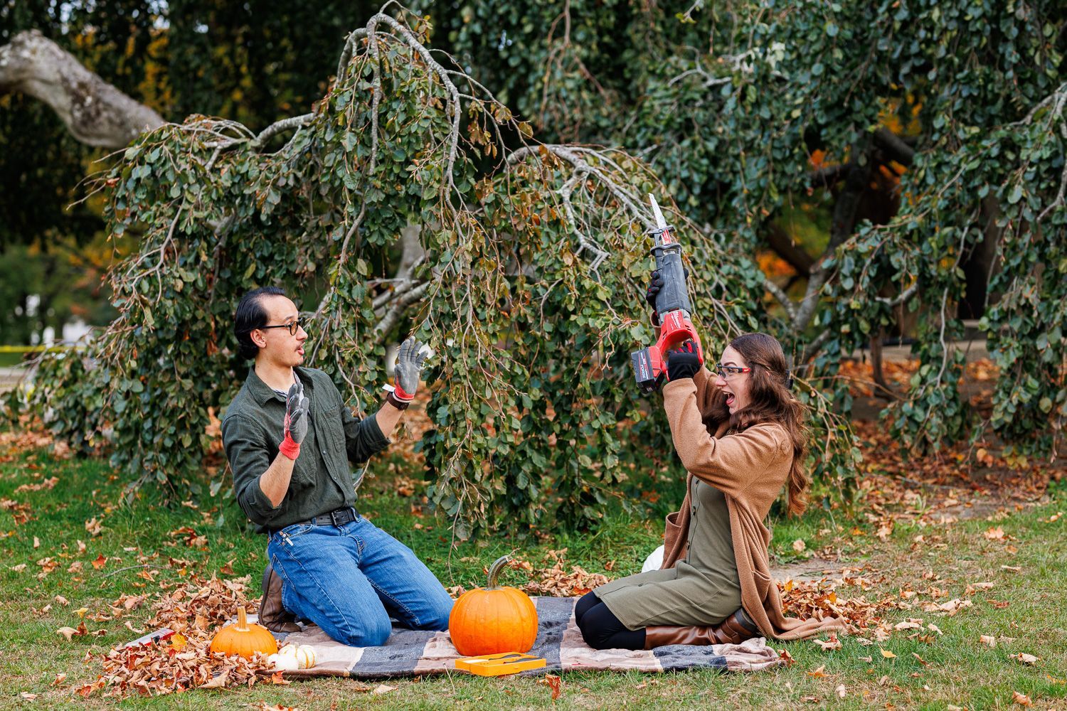 Couple carving pumpkin during engagement session with sawzall