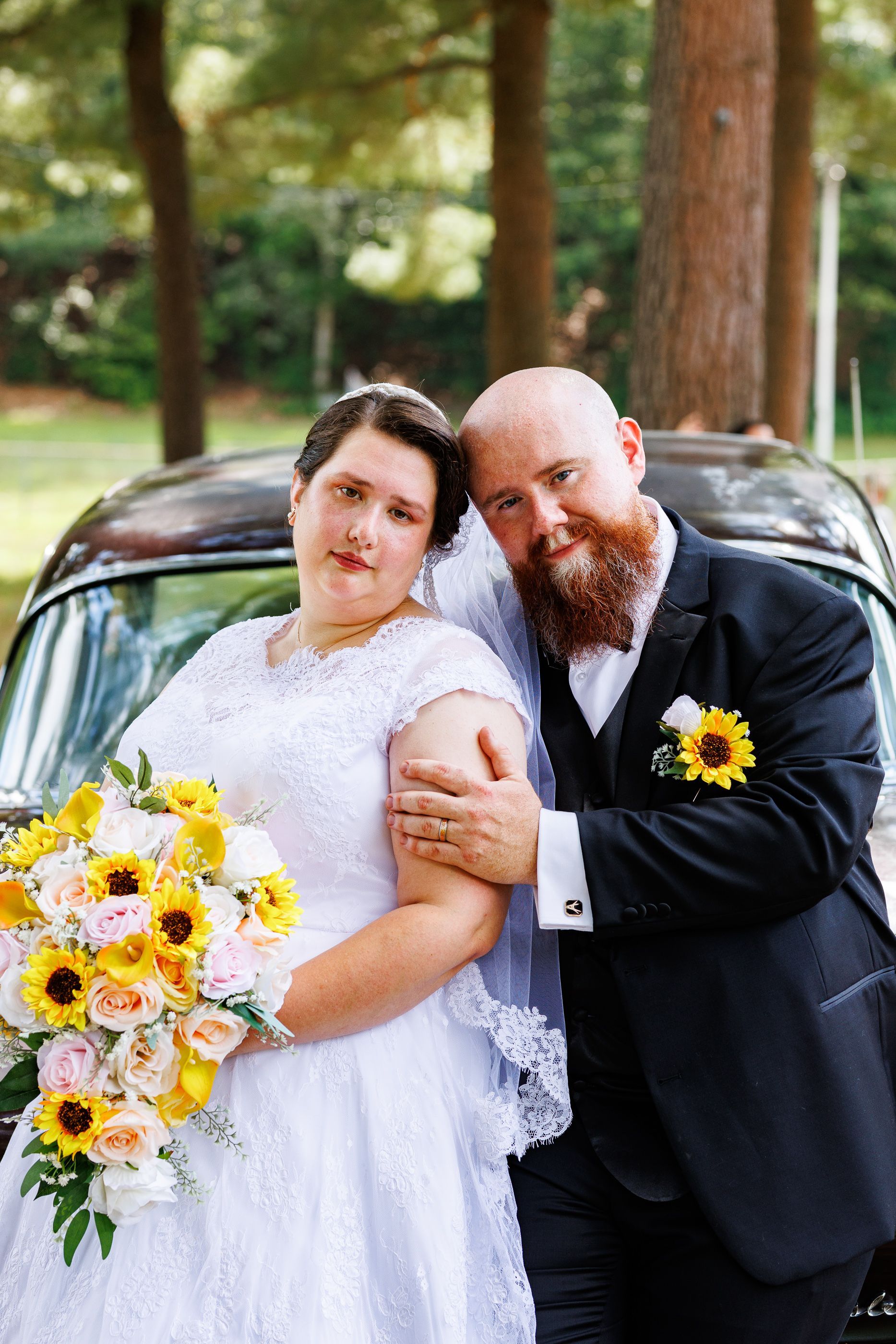 Bride and groom posing with antique Chevy