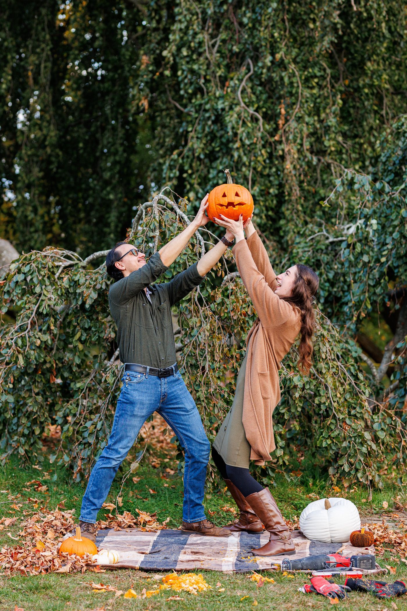 Couple carving pumpkin during engagement session with sawzall