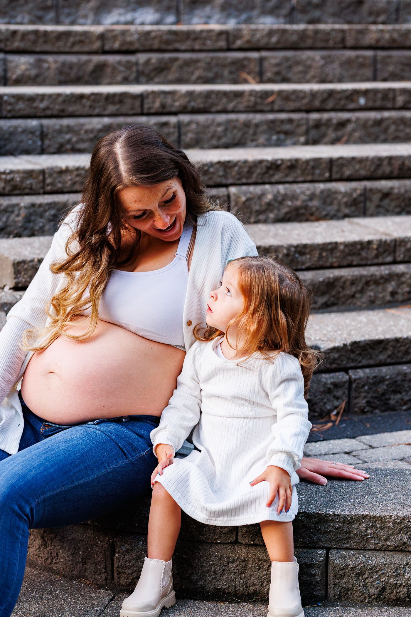 Maternity photography mom posing with toddler while sitting