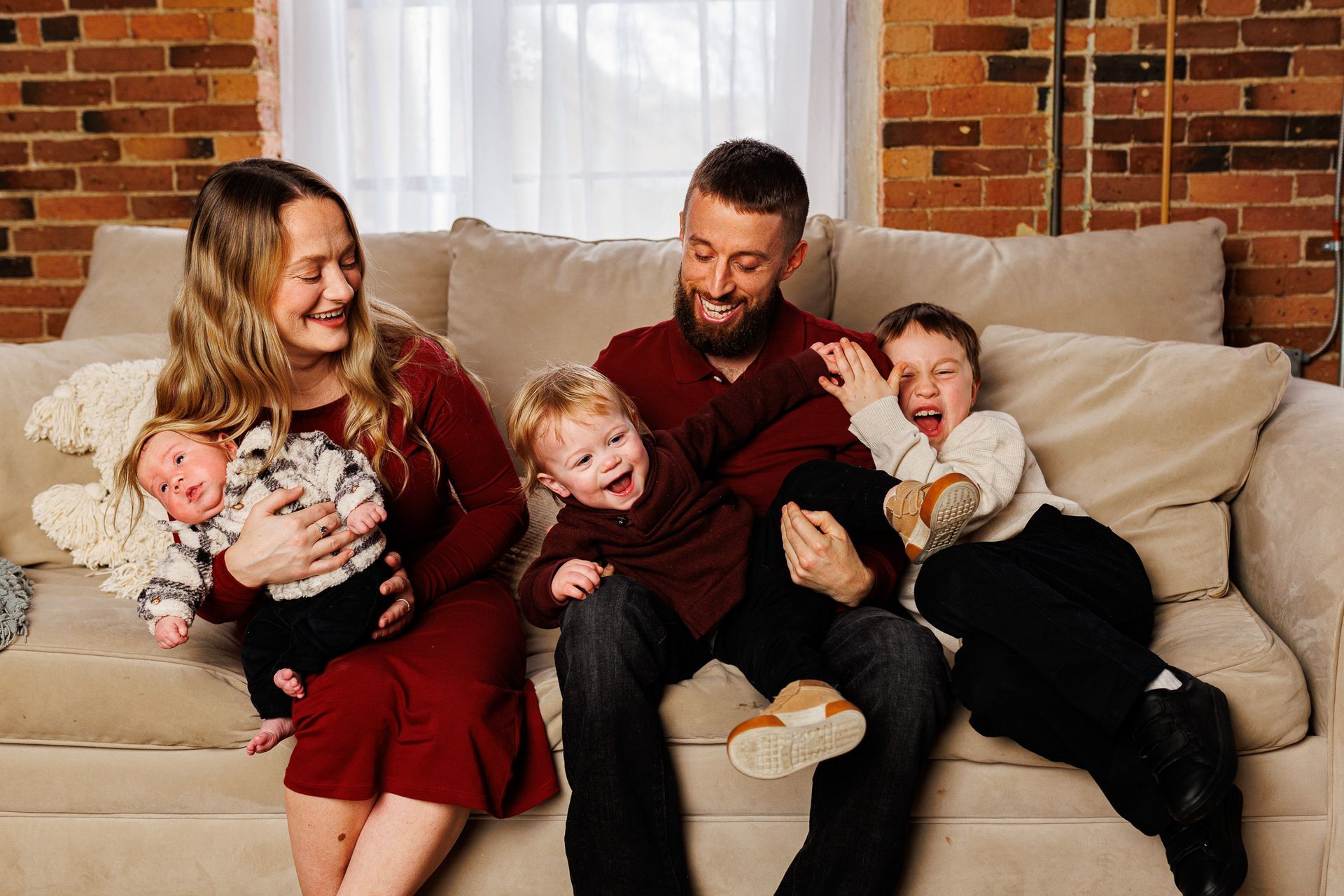 A family is sitting on a couch with three children.