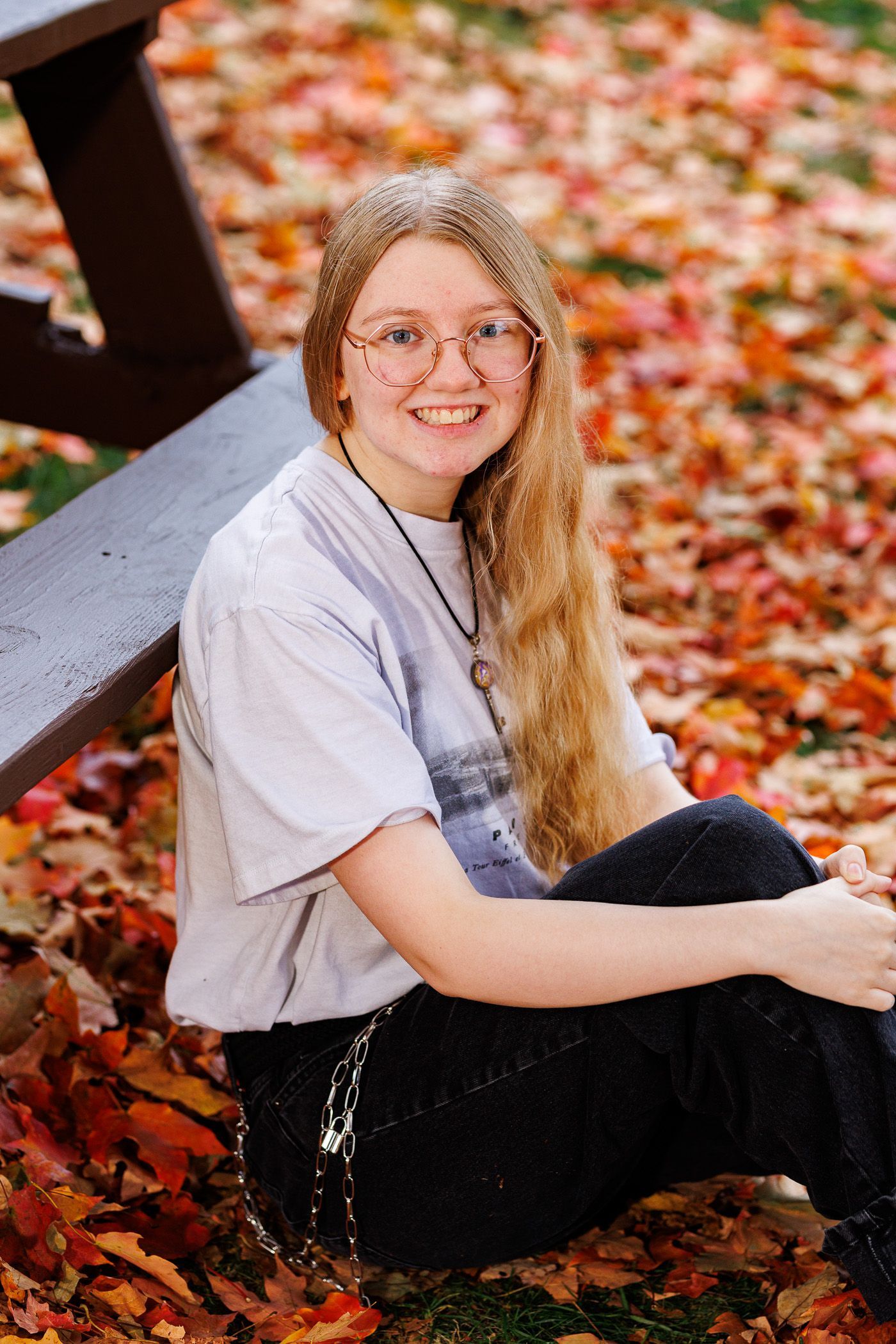 High school senior - senior photography - female student sitting by table in leaves