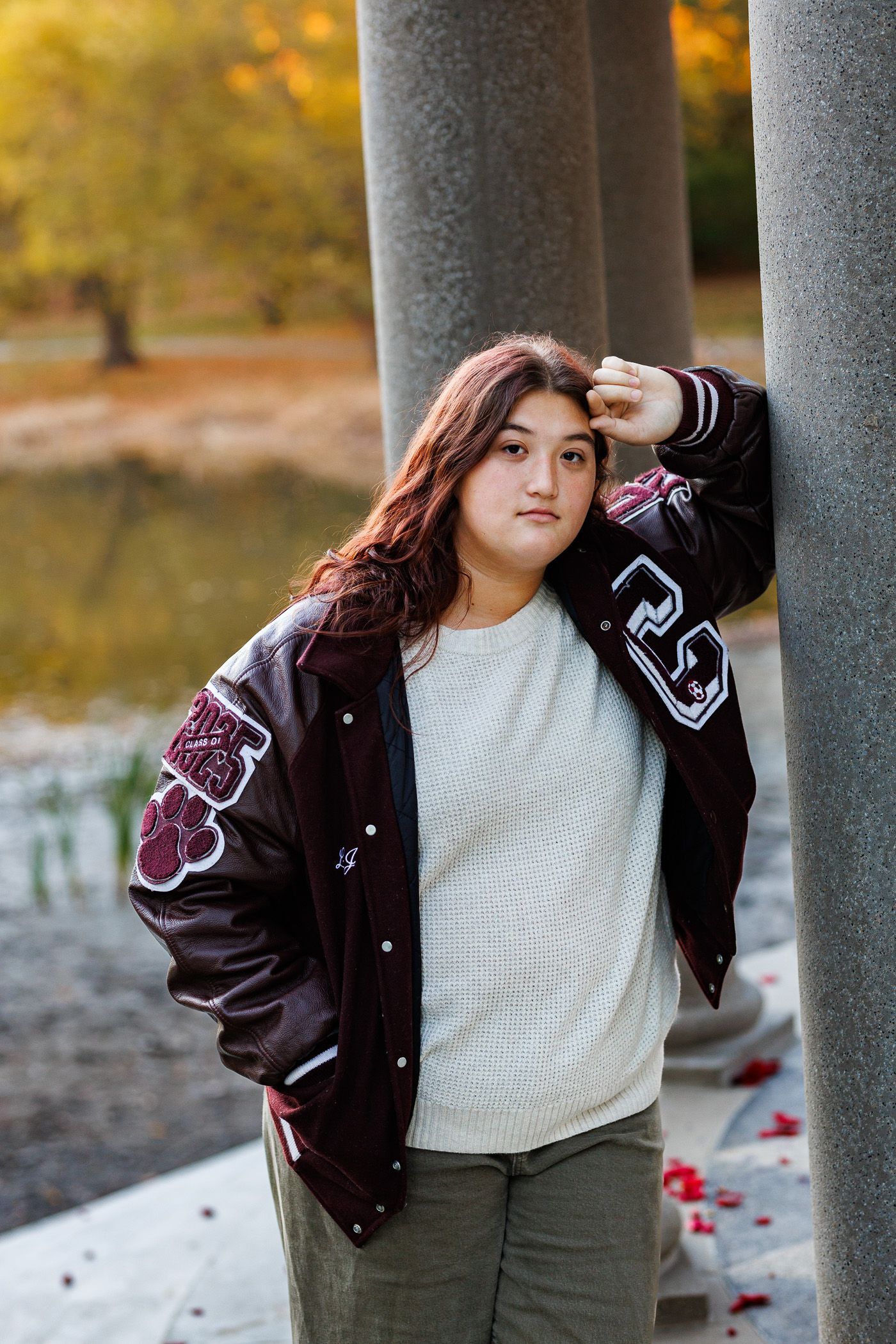 High school senior - senior photography - female student leaning against stone pillar