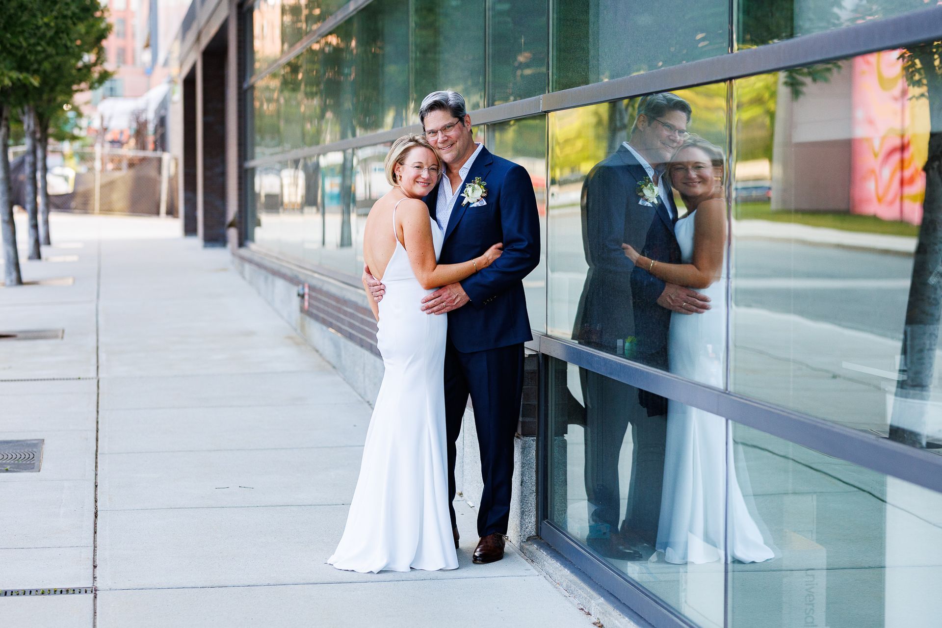 wedding couple posing in front of glass building in Providence, RI